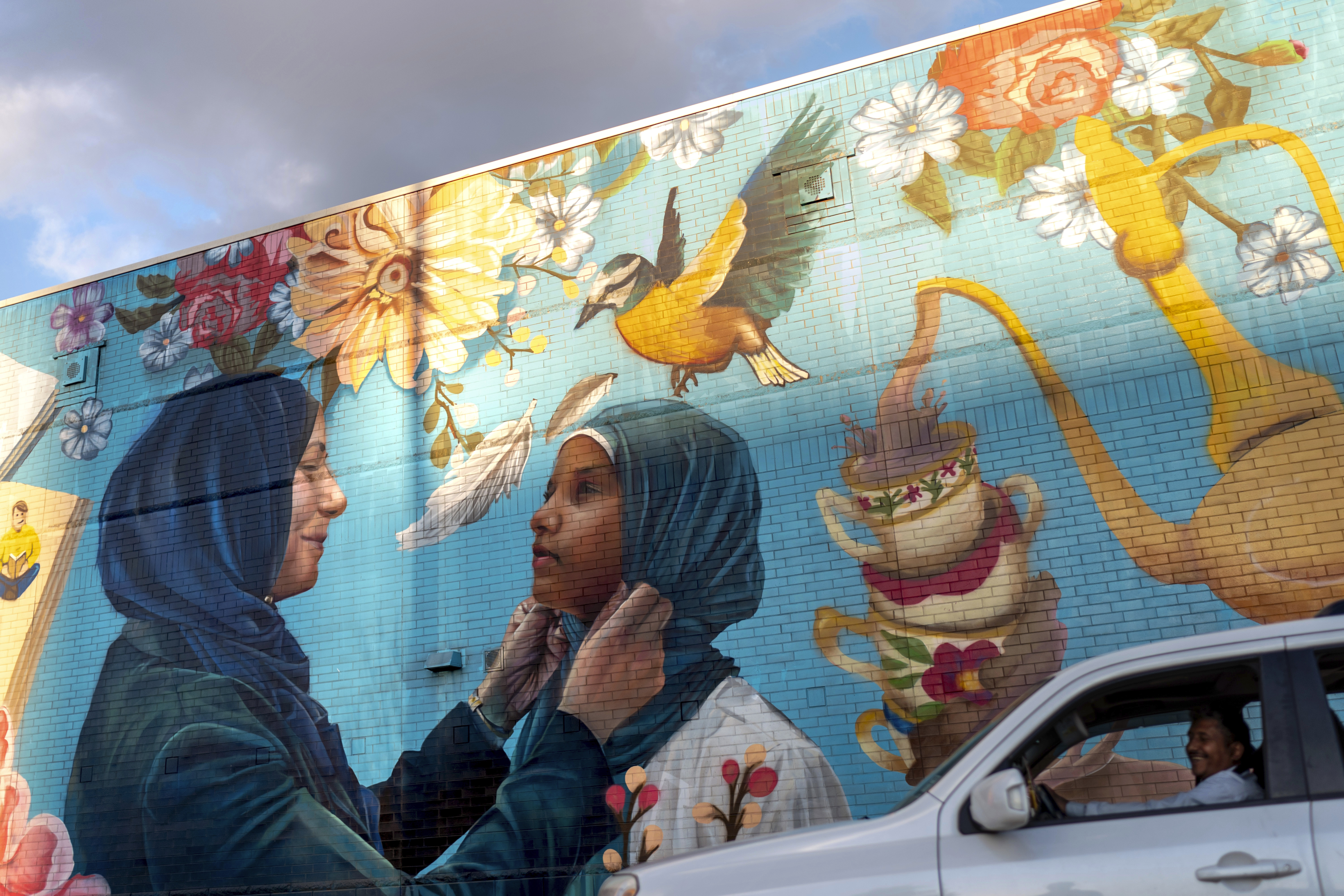 A motorist passes a mural painted on the side of a school, in Dearborn, the nation's largest Arab-majority city.