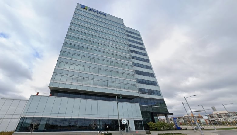 A tall glass office building with the name "Aviva" at the top stands with a cloudy sky in the background.