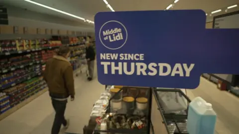 Two men shopping in Lidl middle aisle