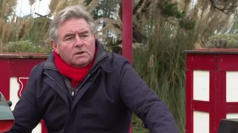 Norman Wallis sitting on a miniature train