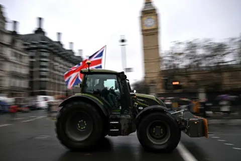 BEN STANSALL/AFP A farmer drives a tractor and waves a Union flag near Big Ben