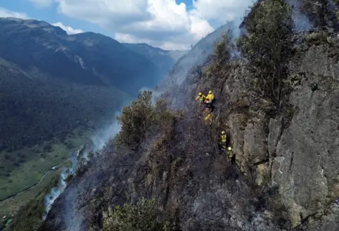 Santiago Arcos/Reuters A drone view shows firefighters while they work to extinguish a wildfire at El Cajas National Park