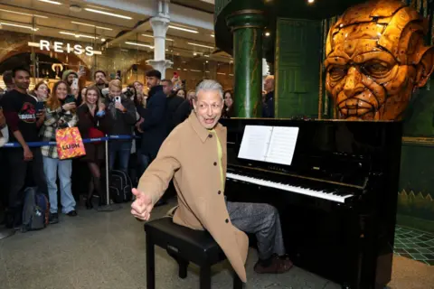 Lia Toby/Getty Images Crowds watch as Jeff Goldblum performs on at St Pancras International Station in London