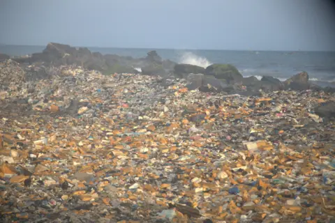 Plastic and other waste including from e-waste are washed back by the sea at the Jamestown seaside area in Accra