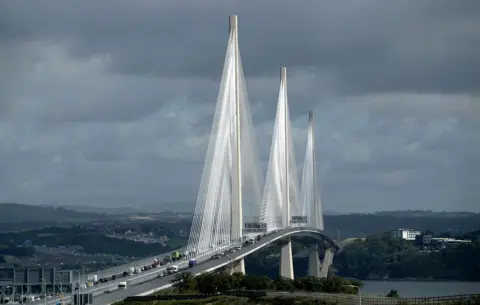 PA Media The three towers of the Queensferry Crossing with cables supported the arched rise of the motorway which is busy with traffic