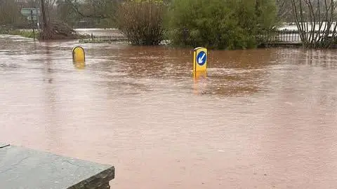 Connor Turner Flooded roads outside the Vine Tree pub in Crickhowell. You can see road sign markings sticking out from the middle of the road emphasising how the deep the water is. They are half covered,