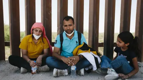 Getty Images A family from India seeking aslyum in the US rests at the border with Mexico, in Yuma Arizona, USA, 20 May 2022