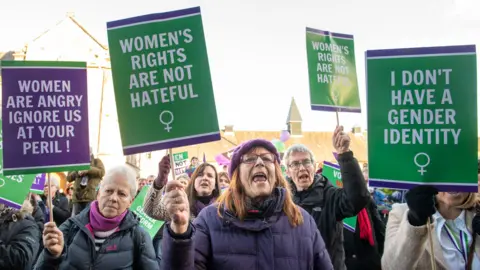 Getty Images Protest outside the Scottish Parliament by women's rights campaigners, holding placards reading "women are angry, ignore us at your peril", "women's rights are not hateful", and "I don't have a gender identity"