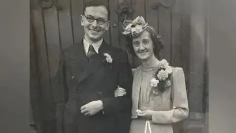 Family photo John and Blodwen Tinniswood, wearing their wedding outfits, in a black and white photo