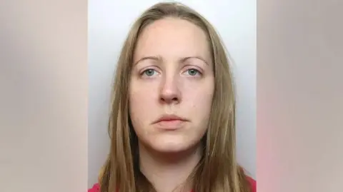 Cheshire Constabulary A police mugshot of Lucy Letby, who has straight blonde hair and stares into the camera with a blank expression