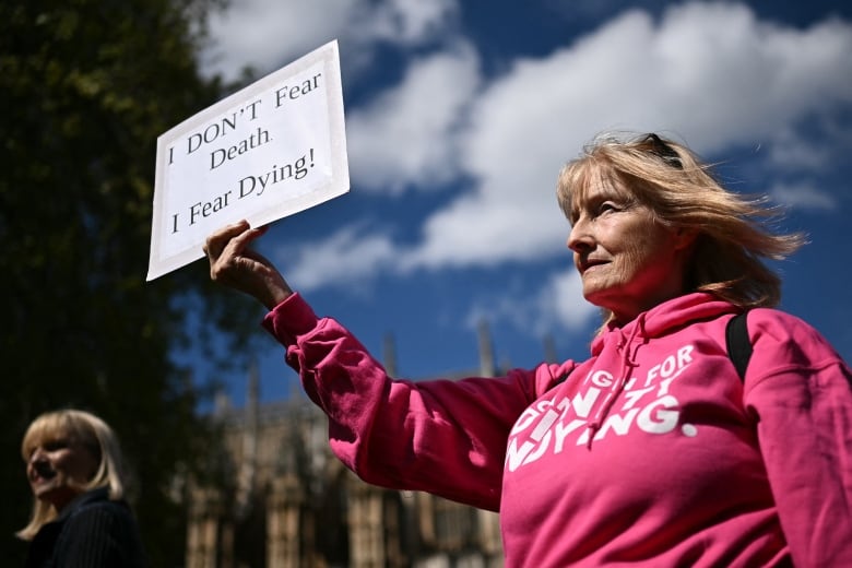 A disability campaigner from "Dignity in Dying" holds a placard as she demonstrates outside The Palace of Westminster, on April 29, 2024. There have been multiple attempts to legalize assisted dying in the UK over the past 20 years although none have been successful.