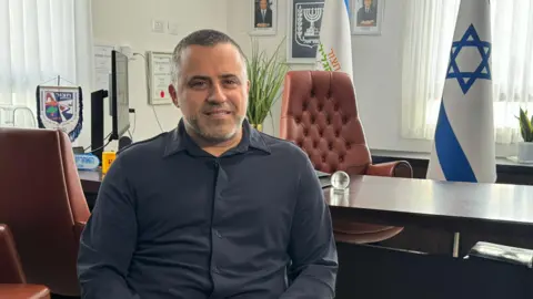 Mayor Kabesa in his office with an Israeli flag on his desk