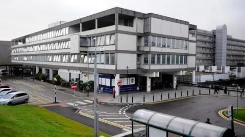 Getty Images Aberdeen Royal Infirmary exterior shot of building on grey day with bus stop and cars parked in foreground