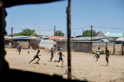 Simon Maina/AFP Men play football on a makeshift field in Windhoek 