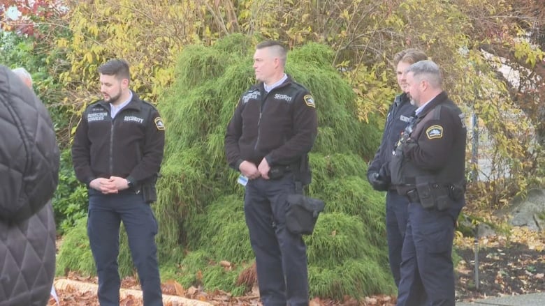 A group of three people in security uniforms.