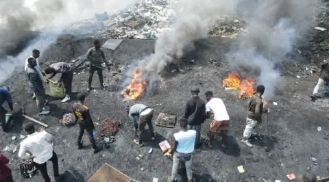 BBC Men at the Agbobloshie dump burning cables and plastic.