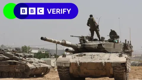 EPA Israeli troops boarding a tank near the Gaza border. 