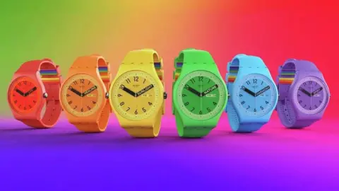 Swatch Six Swatch watches, each a bright colour. A rainbow pattern is on the strap