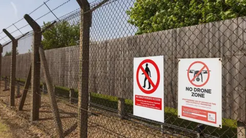 Mark Kerrison/Getty A chain-link fence with barbed wire at RAF Lakenheath displaying a warning sign that says drones are prohibited