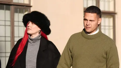 PA Media Tyron Frampton, known by the stage name Slowthai, arriving at Oxford Crown Court, where he is accused of two charges of rape. Alongside him is his wife Anne-Marie