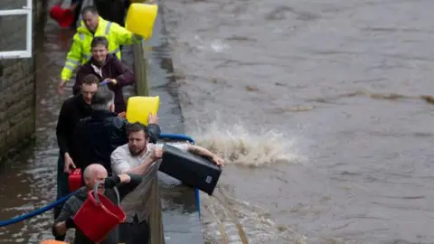 Getty Images Pontypridd residents bail out their houses after flooding