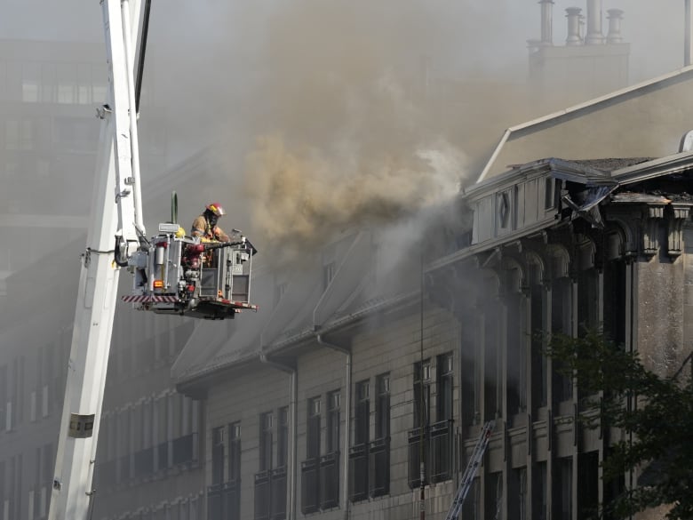 A firefighter battles a blaze in Old Montreal on Friday, Oct.4, 2024. 