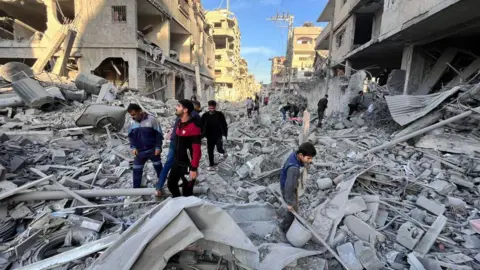 AFP Palestinians search for survivors after an Israeli air strike in Beit Lahia, northern Gaza (17 November 2024)