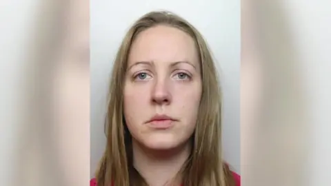 Cheshire Constabulary A woman with brown hair looks at the camera in a police mugshot.