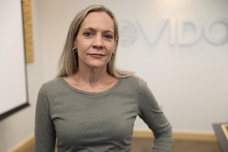 Angie Rasmussen pictured with the VIDO logo on a wall behind her