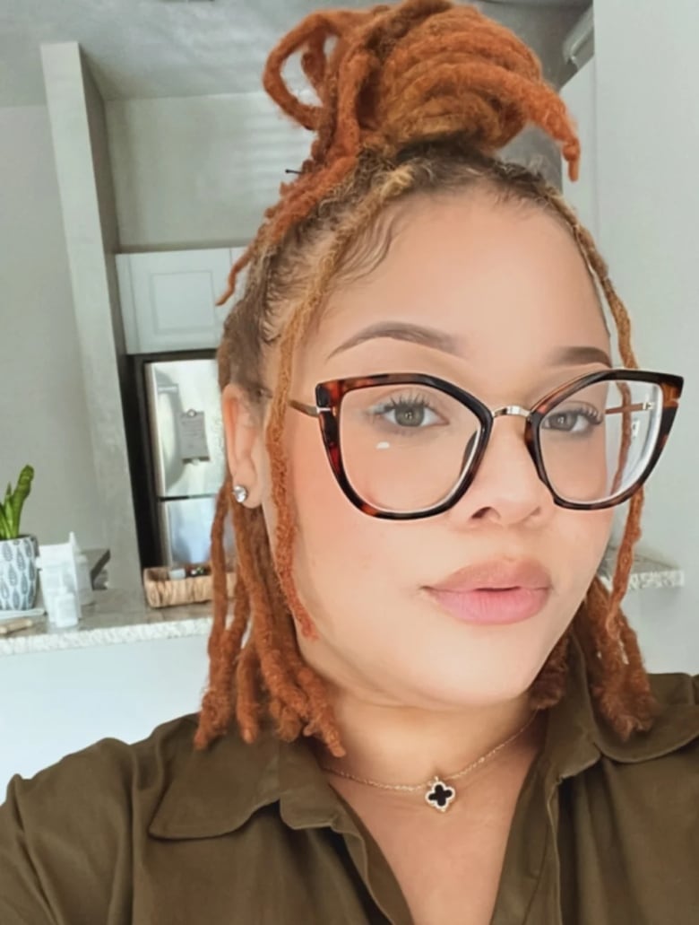 Photo of Danyale Freeman, a Black woman with red hair and glasses.