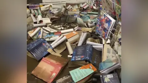 Cerith Mathias Piles of books in huge puddle of water