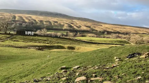 Scenic photo of hills and clouds in the sky.