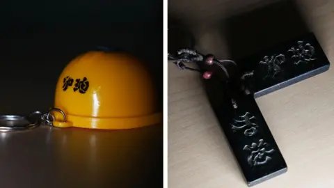 BBC Chinese / Lok Lee Composite picture of Hong Kong protest memorabilia - a yellow helmet and  a slogan carved in wood. 