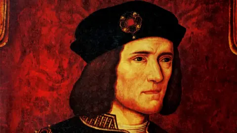 Getty Images A portrait of Richard III. He is wearing a black hat, with a brooch on it and has long brown hair.