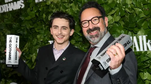 Getty Images Timothée Chalamet, James Mangold pose with their Visionary Tribute awards for "A Complete Unknown" at the 34th Annual Gotham Awards held at Cipriani Wall Street on December 02, 2024 in New York