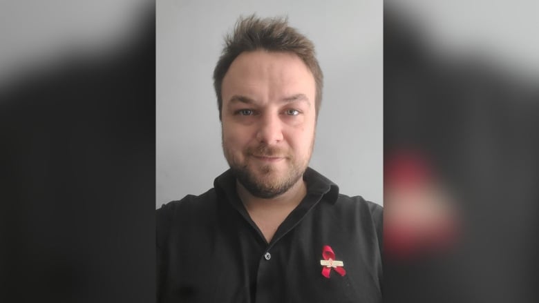 A headshot of a person wearing a black shirt.