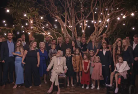 Parlophone Records Actor Dick Van Dyke sits in a chair while surrounded by his children and grandchildren in Malibu