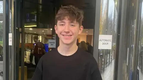 Tracey Concannon Joshua with brown curly hair and black T-shirt standing outside RTE studios in Dublin