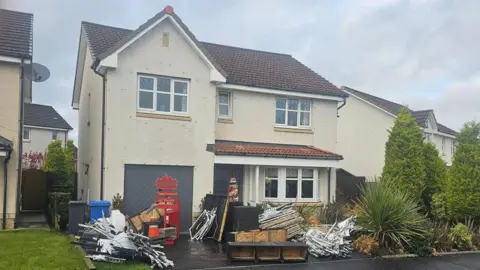 Gary Gray A house with piles of Christmas decorations across the front garden. 