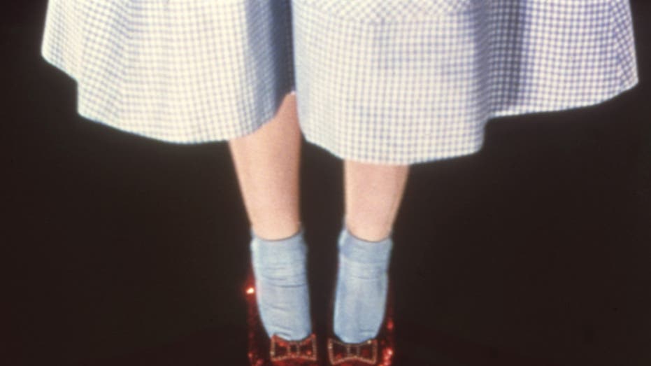 a close-up of judy garland wearing the ruby slippers