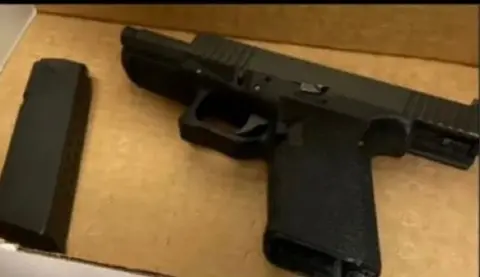 CBS News A black handgun with a clip removed is seen as evidence