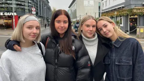 George Carden/BBC Mid shot of four young female students standing on a Brighton street looking to camera. From left to right - From left: Maddie Bunting, Lauren Hart, Millie Winchester, Blyth Eling, all students from the University of Brighton