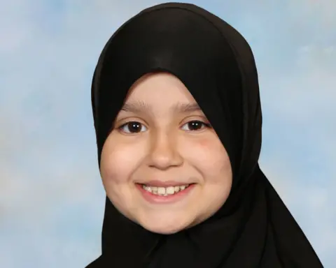 Surrey Police handout Sarah smiles looking directly at the camera. She is wearing a black hijab