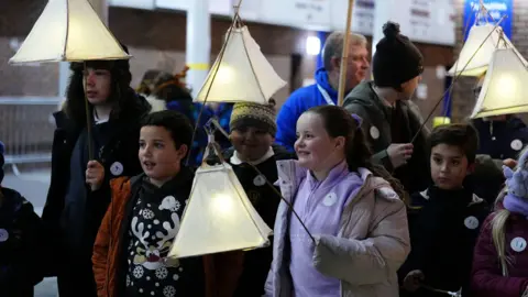 PA Media Five children holding lanterns 