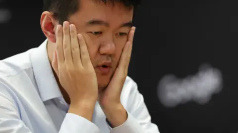 EPA Ding Liren holds his hand in his face after realising his crucial mistake during the final game of the 2024 World Chess Championship