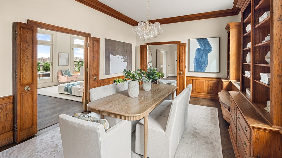 The dining room features dark hardwood flooring, mixed textured walls and built-in cabinetry.