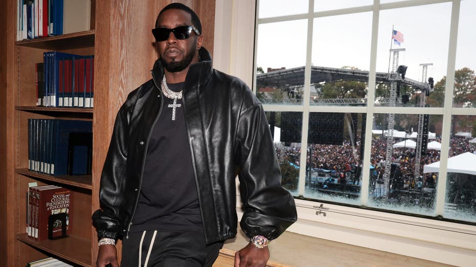 Sean "Diddy" Combs wears black leather jacket by a window.