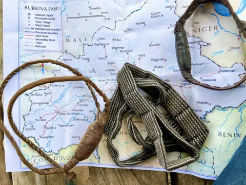 Thomas Naadi / BBC Amulets lying on a map of West Africa