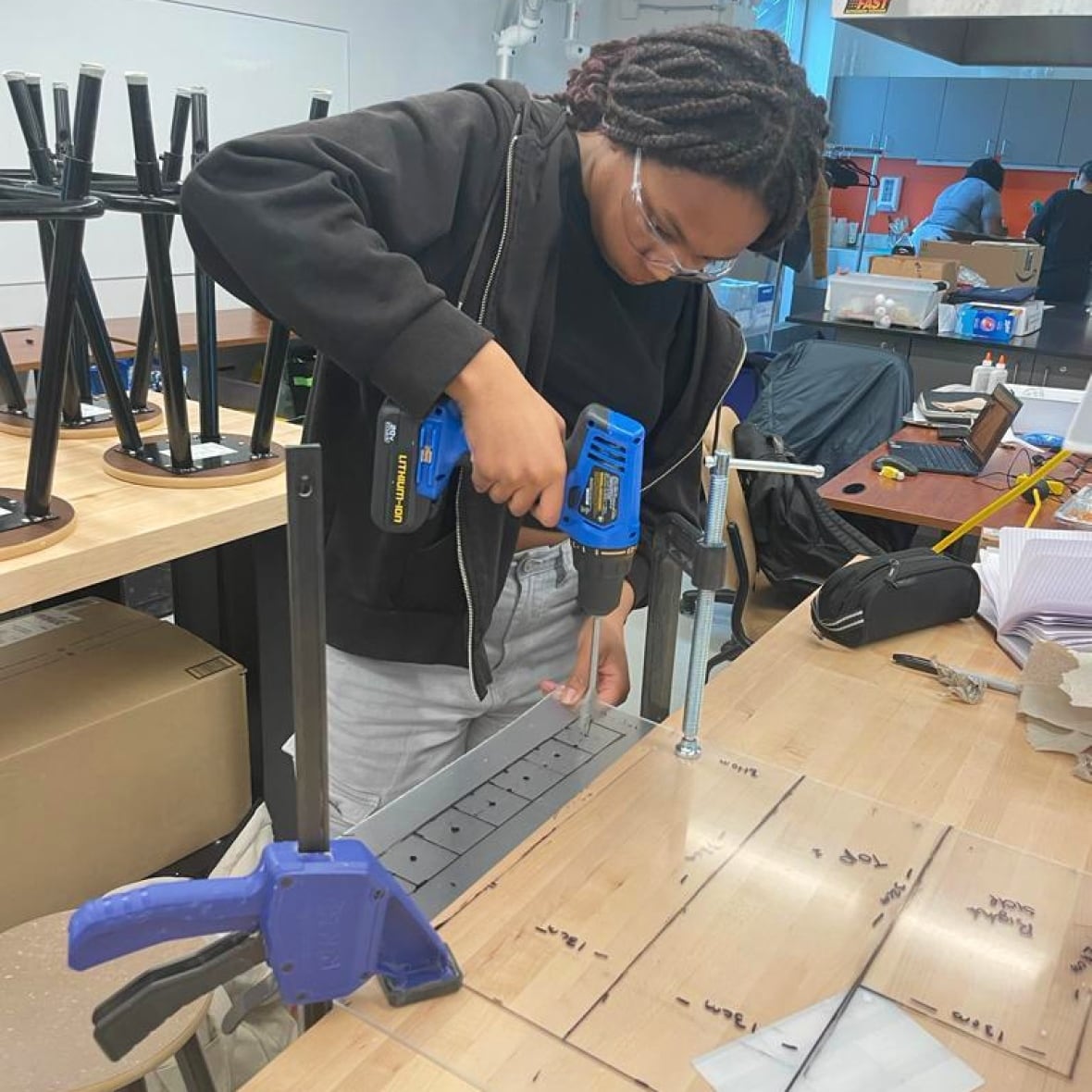 A Black teenage girl is shown in a science lab.