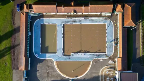 Getty Images A swimming pool seen from above full of brown water